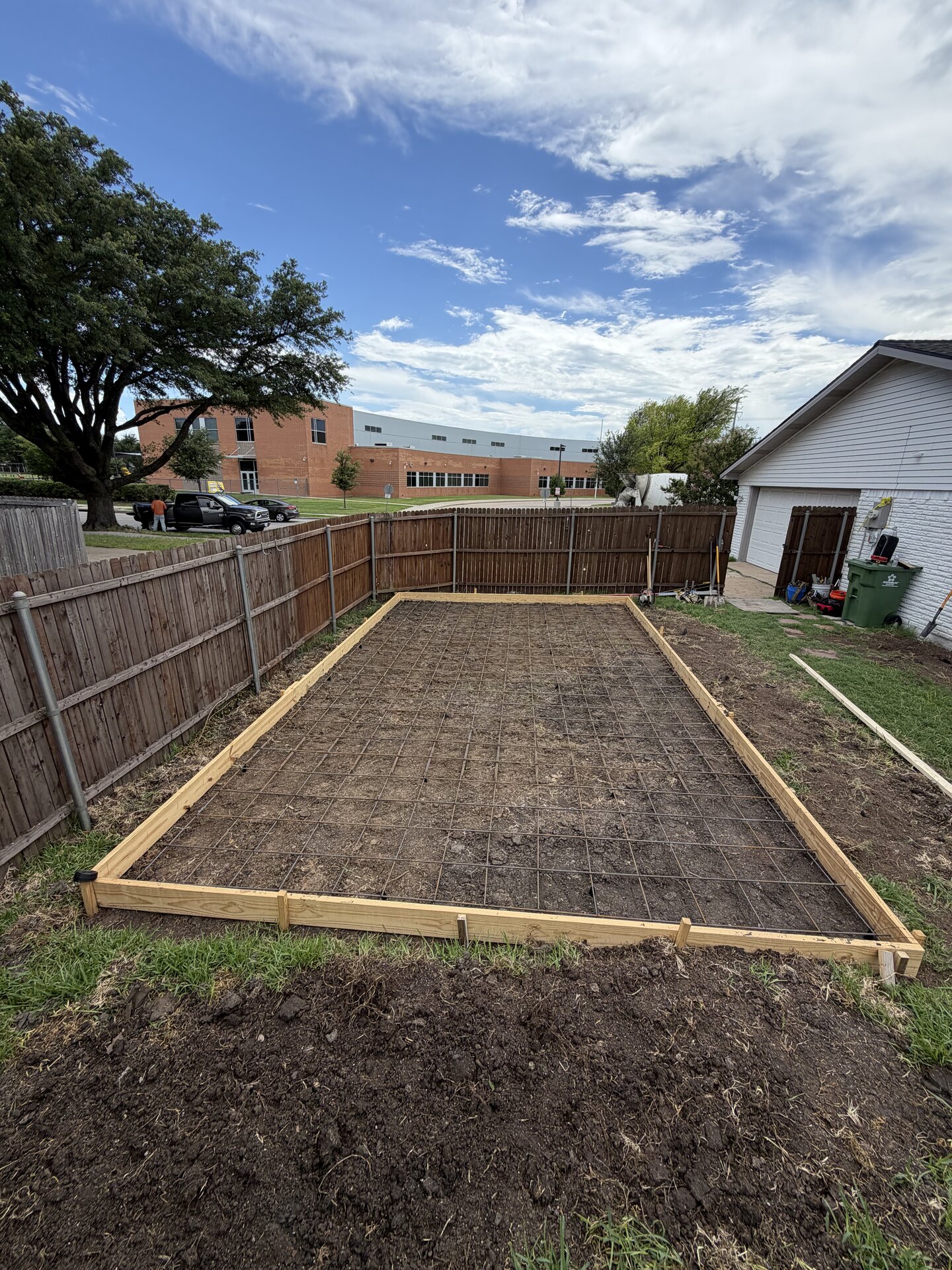 Backyard concrete pad with turf border — before
