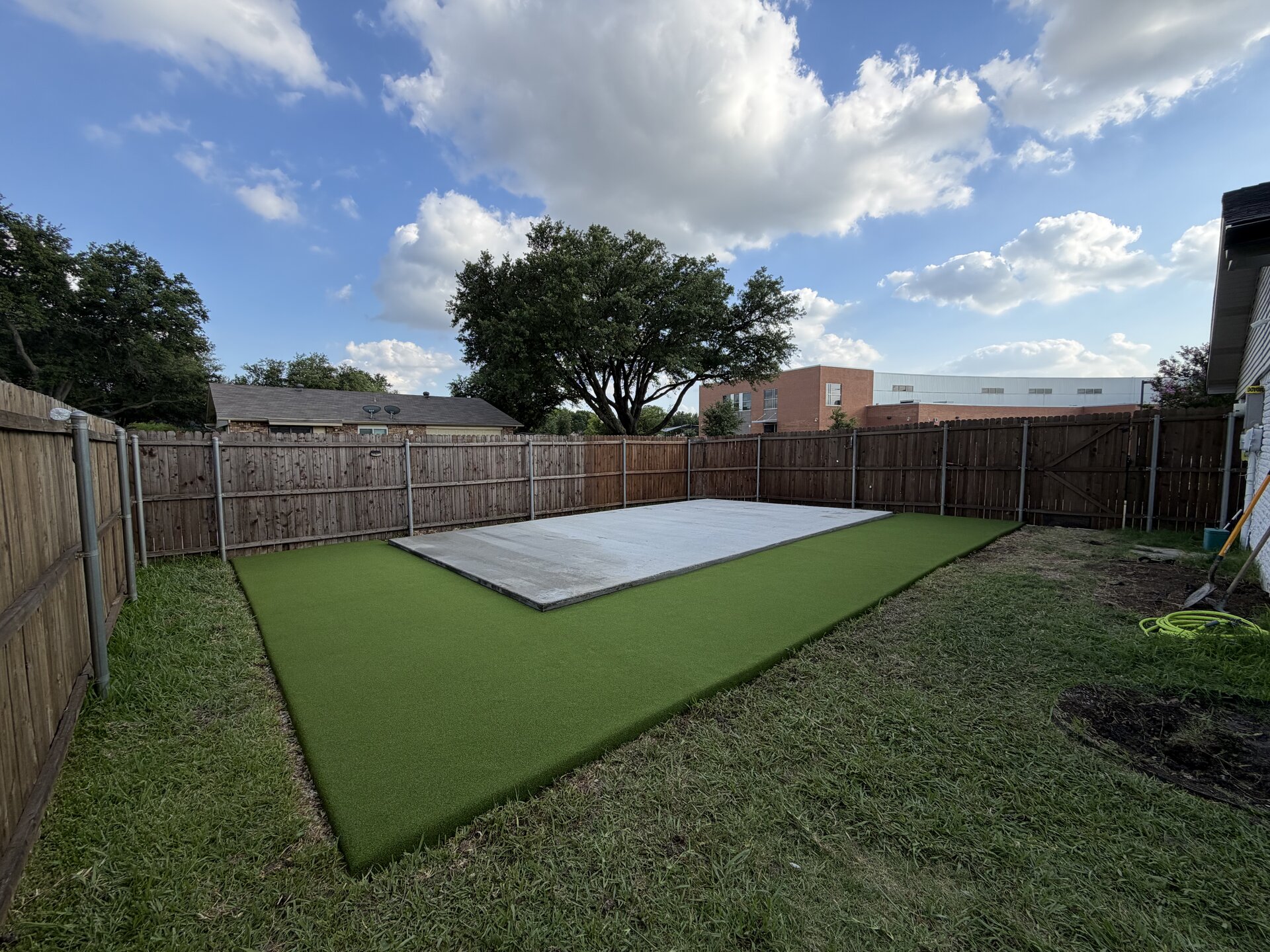 Backyard concrete pad with turf border — after